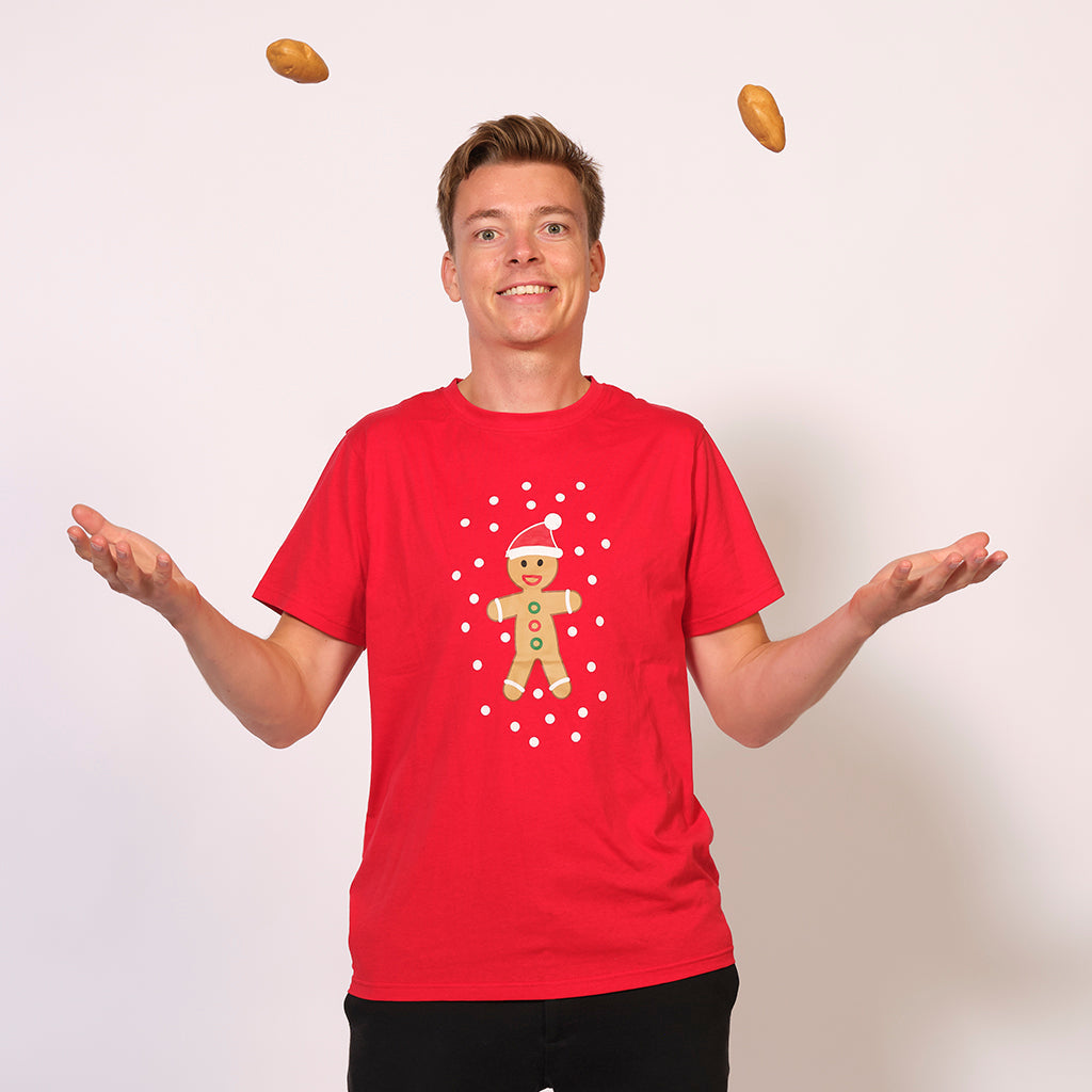 En mang jonglerer, mens han har en rød T-shirt med juletema på.